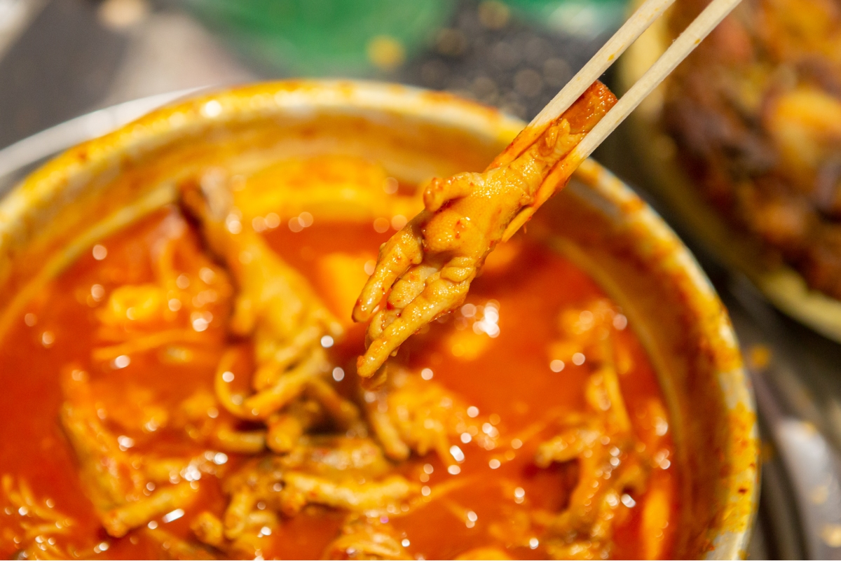Chicken feet in soup lifted with chopsticks