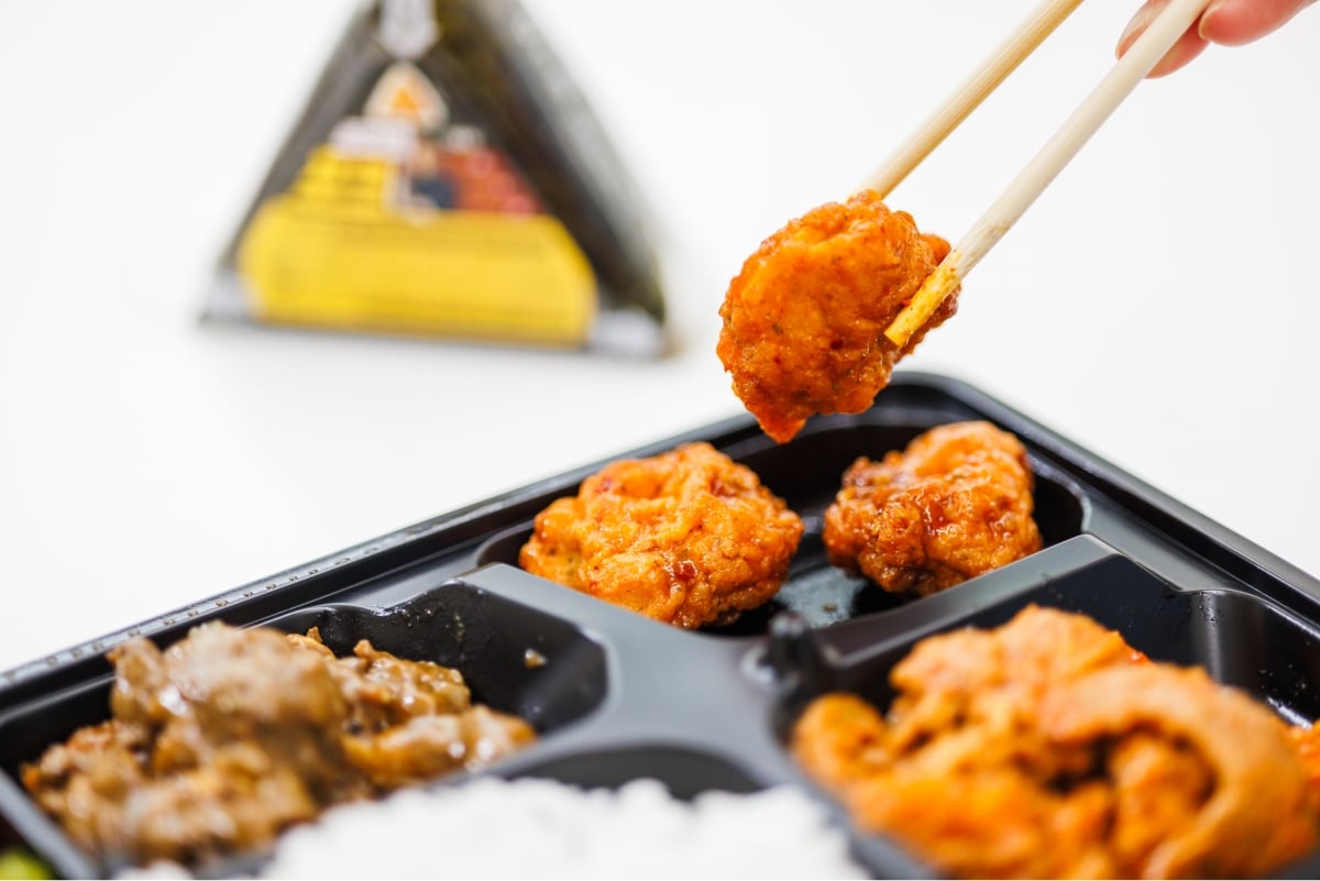 Photo of lifting ingredients from a lunch box with chopsticks