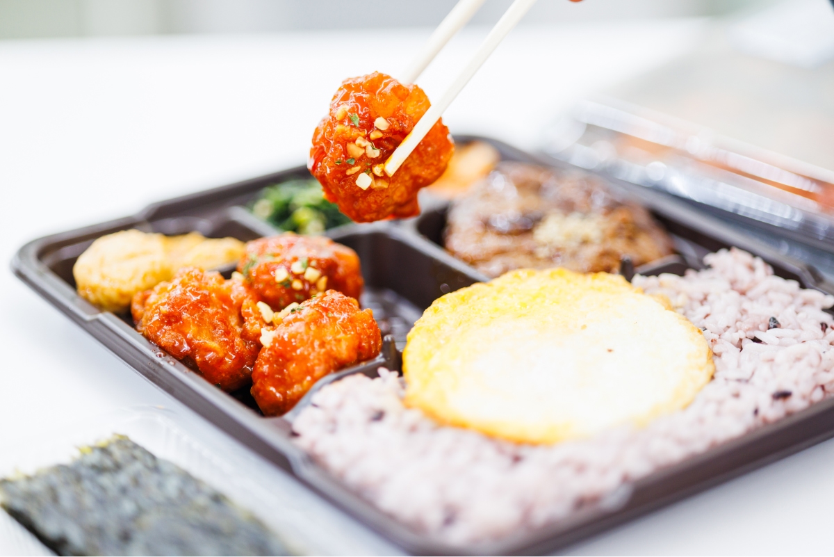 Photo of lifting ingredients from a lunch box with chopsticks