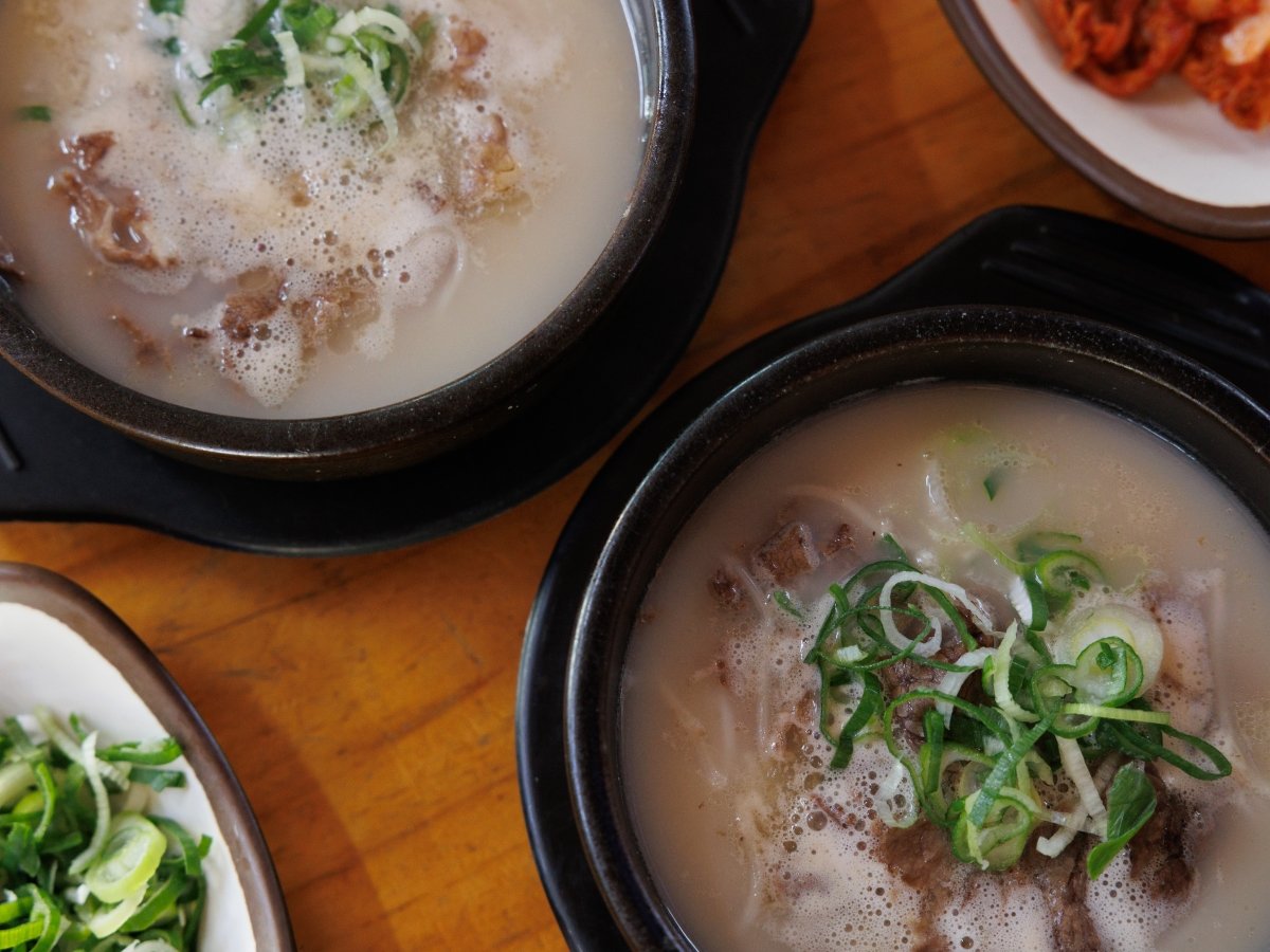 Two bowls of Seolleongtang and side dishes